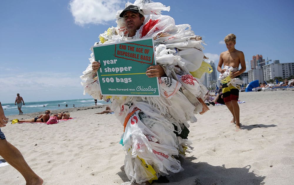 Steve Vincenti of Miami walks on the beach wearing 500 plastic shopping bags, protesting the use of disposable bags, during a Hands across the Sand event, part of simultaneous events happening globally to raise awareness of the need to end our dependence on fossil fuels and transition to clean energy. 