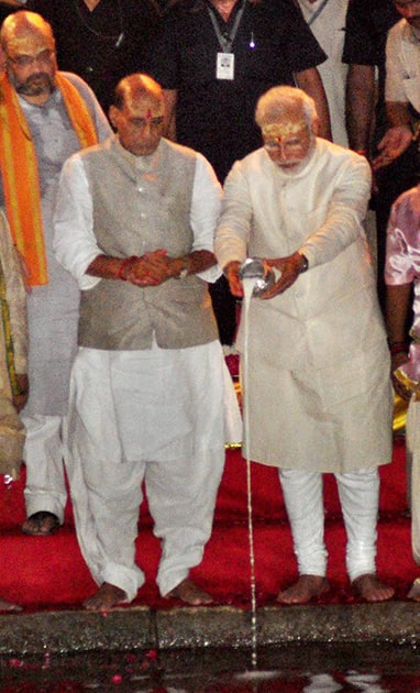 BJP leader and the next Prime Minister Narendra Modi with party President Rajnath Singh and Amit Shah offering milk to Ganga during the Aarti in Varanasi.