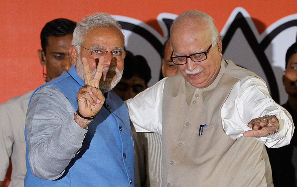 Narendra Modi, left, flashes the victory symbol standing next to senior party leader L.K. Advani at the party headquarters in New Delhi.