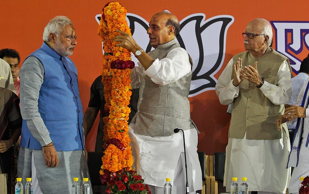 Bharatiya Janata Party (BJP) President Rajnath Singh offers a giant floral garland to India`s next prime minister Narendra Modi at the party headquarters in New Delhi.