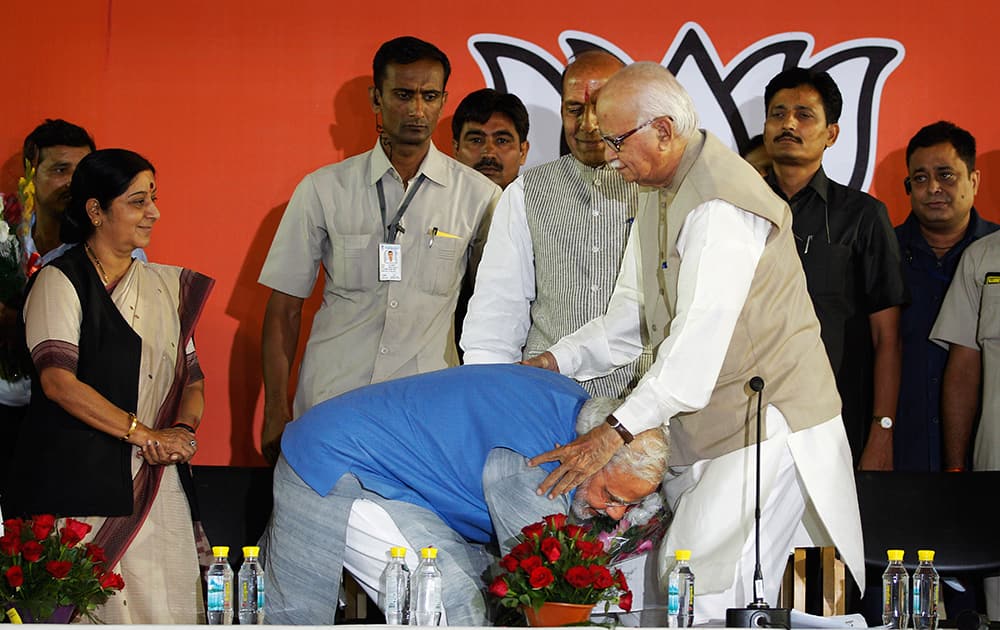 Narendra Modi touches, as an act of respect, the feet of senior party leader L.K. Advani at the party headquarters in New Delhi.