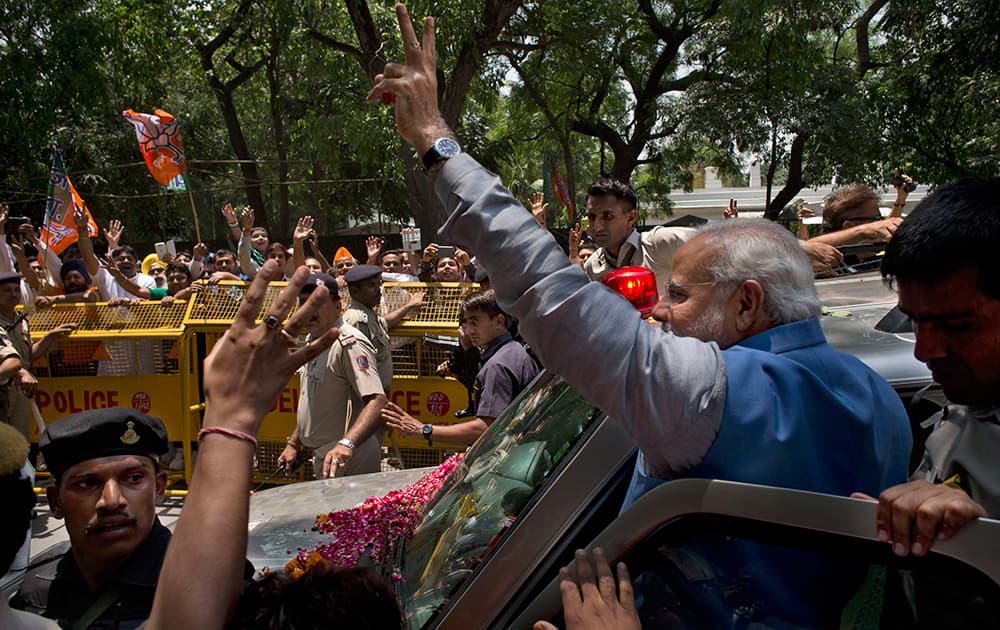 Narendra Modi greets the crowd with a victory symbol outside the party headquarters in New Delhi.