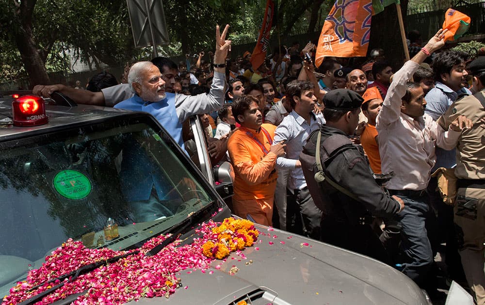 Bharatiya Janata Party (BJP) leader and India`s next prime minister Narendra Modi greets the crowd with a victory symbol outside the party headquarters in New Delhi.