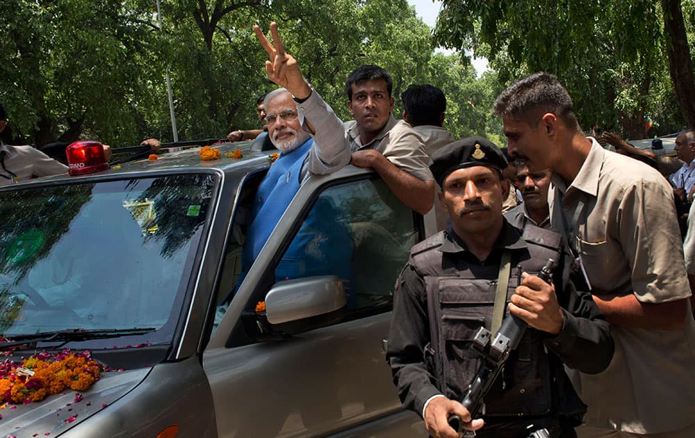 Bharatiya Janata Party (BJP) leader and India`s next prime minister Narendra Modi greets the crowd with a victory symbol outside the party headquarters in New Delhi.