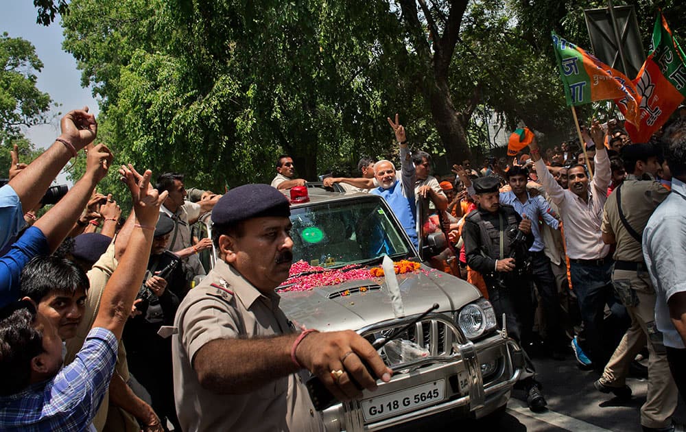 Bharatiya Janata Party (BJP) leader and India`s next prime minister Narendra Modi greets the crowd with a victory symbol outside the party headquarters in New Delhi.