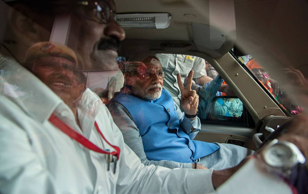 Bharatiya Janata Party (BJP) leader and India`s next prime minister Narendra Modi greets the crowd with a victory symbol outside the New Delhi airport.