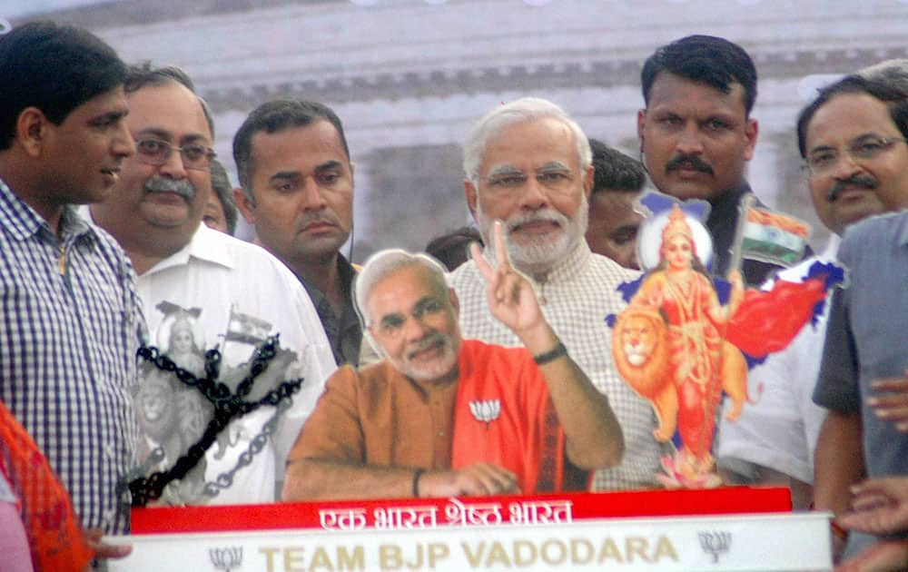 6:35 PM Narendra Modi being presented a memento at a public meeting in Vadodara.
