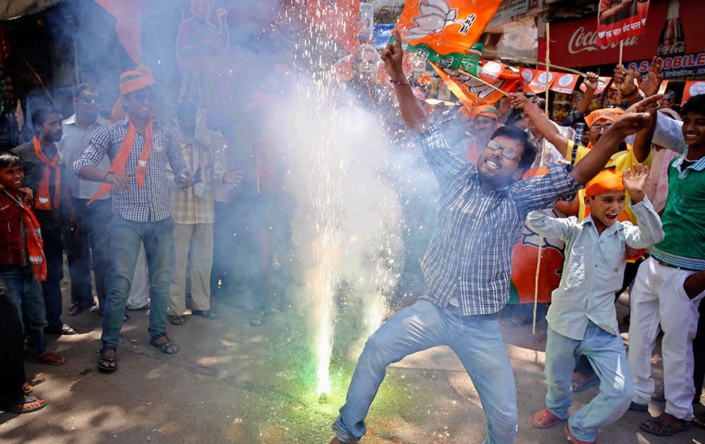 Bharatiya Janata Party (BJP) supporters dance and burst firecrackers to celebrate the news of early election result trends in Allahabad, Uttar Pradesh.