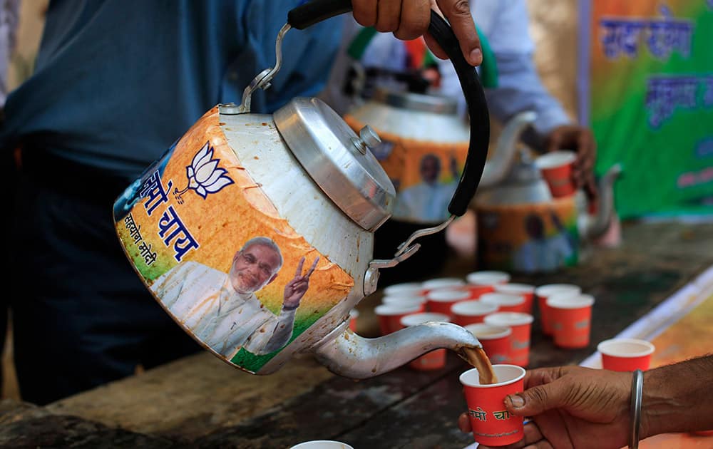 A man pours tea from a kettle with a portrait of Bharatiya Janata Party (BJP) leader and India’s next prime minister Narendra Modi, outside the BJP party office in New Delhi.