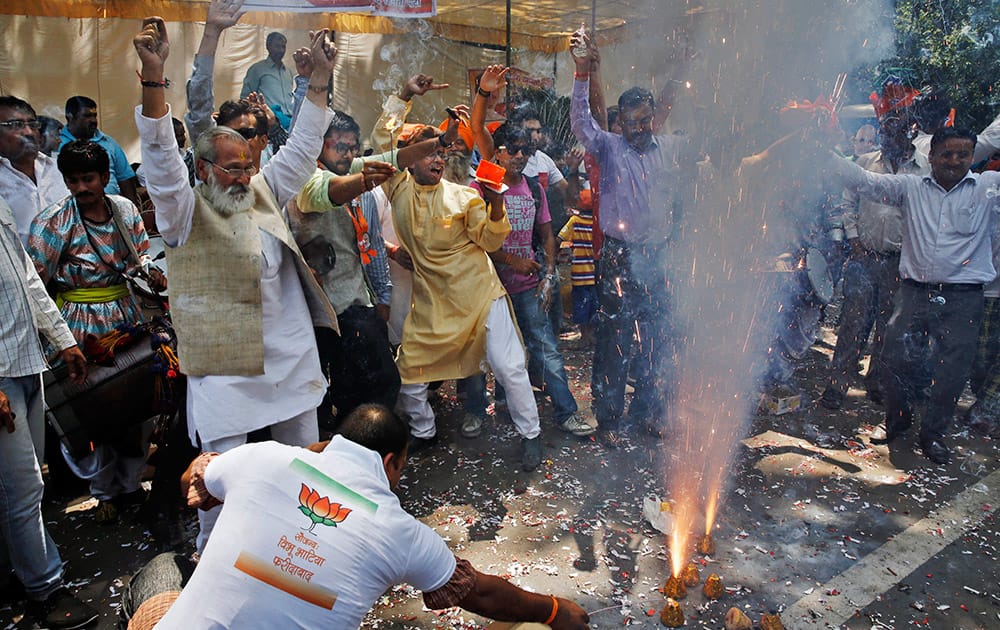 Bharatiya Janata Party (BJP) supporters set off firecrackers and dance to celebrate preliminary results that showed the BJP winning by a landslide, outside the party headquarters in New Delhi.