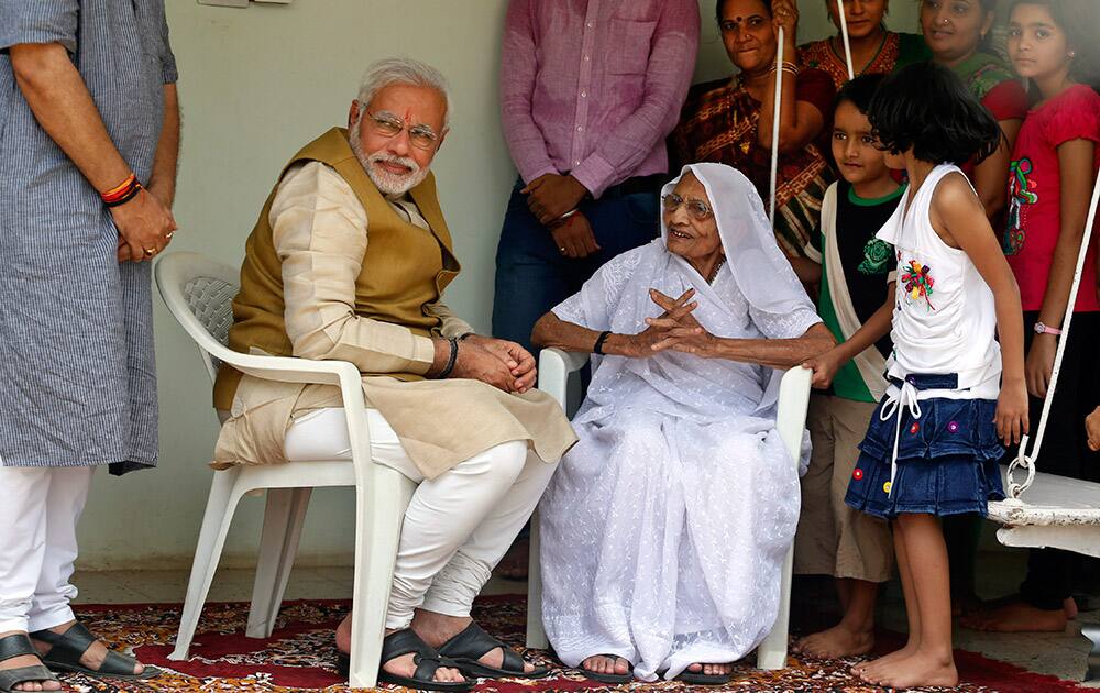 Narendra Modi sits with his 90-year-old mother Hiraben during a visit to seek her blessings after preliminary results showed his party winning by a landslide, in Gandhinagar, Gujarat.