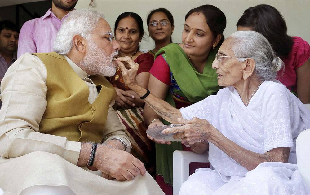 A victorious Narendra Modi is offered sweets by his mother HIRABEN after he saught her blessings at her home in Gandhinagar as election results showed a landslide win for BJP led by him.