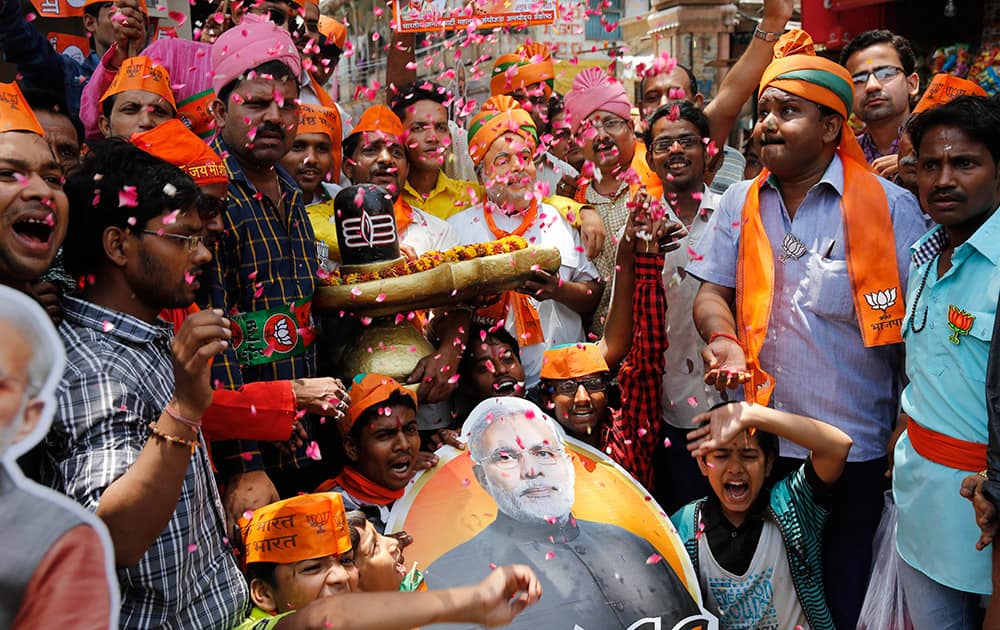 Bharatiya Janata Party (BJP) supporters hold a shivling, a symbolic representation of Hindu God Shiva, and celebrate preliminary results that showed the BJP winning by a landslide in Varanasi, in the northern Indian state of Uttar Pradesh.