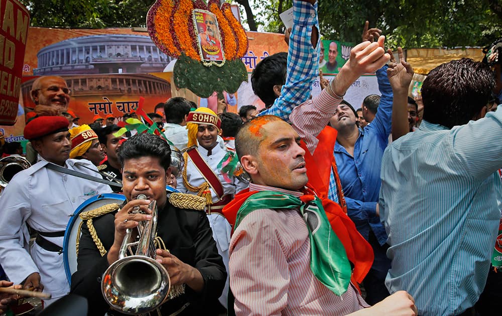 Bharatiya Janata Party (BJP) supporters dance to celebrate preliminary results that showed the BJP winning by a landslide, outside the party headquarters in New Delhi.