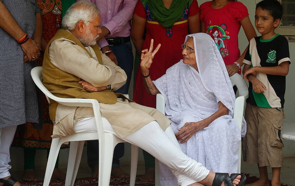 Hiraben, the 90-year-old mother of opposition Bharatiya Janata Party (BJP) leader and India`s next prime minister Narendra Modi, flashes the victory symbol as she celebrates with her son after preliminary results showed the BJP winning by a landslide, in Gandhinagar, Gujarat.