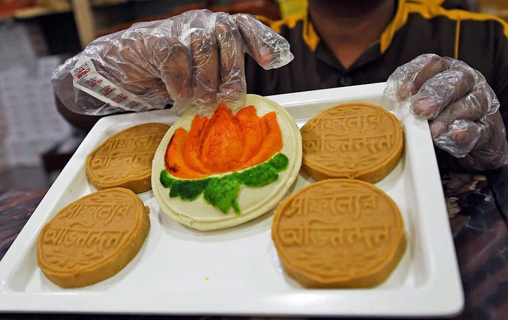 A shopkeeper displays sweets with symbol of BJP and congratulatory messages on the eve of counting of votes in Lok Sabha elections, in Kolkata.