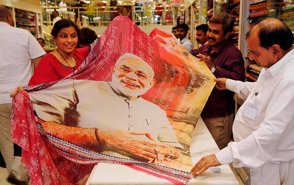 A woman customer holds a sari printed with a portrait of Bharatiya Janata Party`s prime ministerial candidate Narendra Modi at a garments shop in Mumbai.