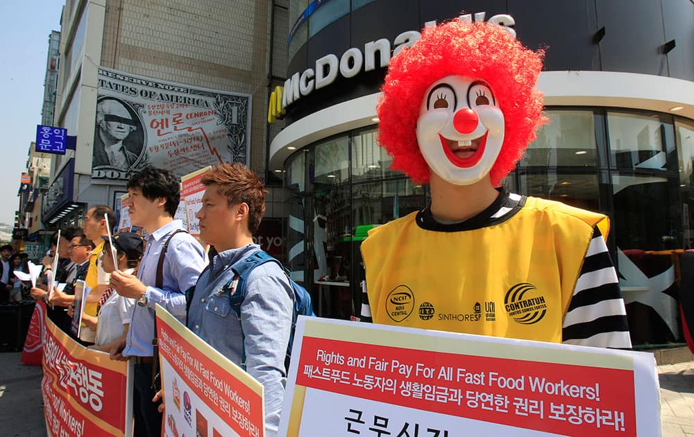 A protester dressed as Ronald McDonald participates in a rally to demand higher wages for fast-food workers outside a McDonald restaurant in Seoul, South Korea.