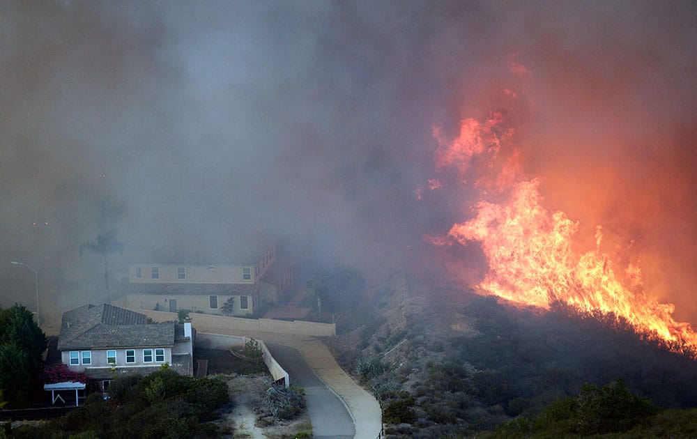 A wildfire approaches homes, in San Marcos, Calif. 