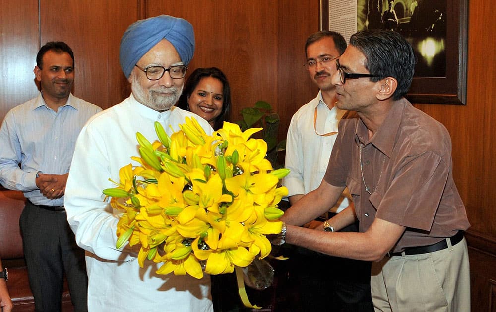 PRINCIPAL SECRETARY PULOK CHATTERJEE PRESENTING A BOUQUET TO PRIME MINISTER MANMOHAN SNGH WHO BID FAREWELL TO THE STAFF AT THE PMO IN NEW DELHI.