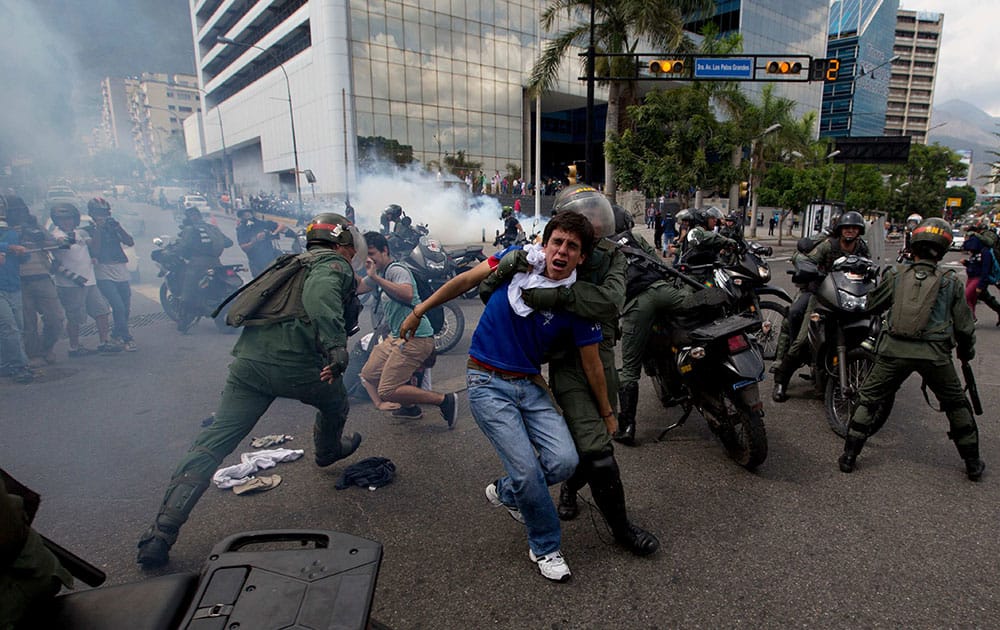 Bolivarian National Guardsmen detain anti-government demonstrators during clashes at a protest in Caracas, Venezuela.