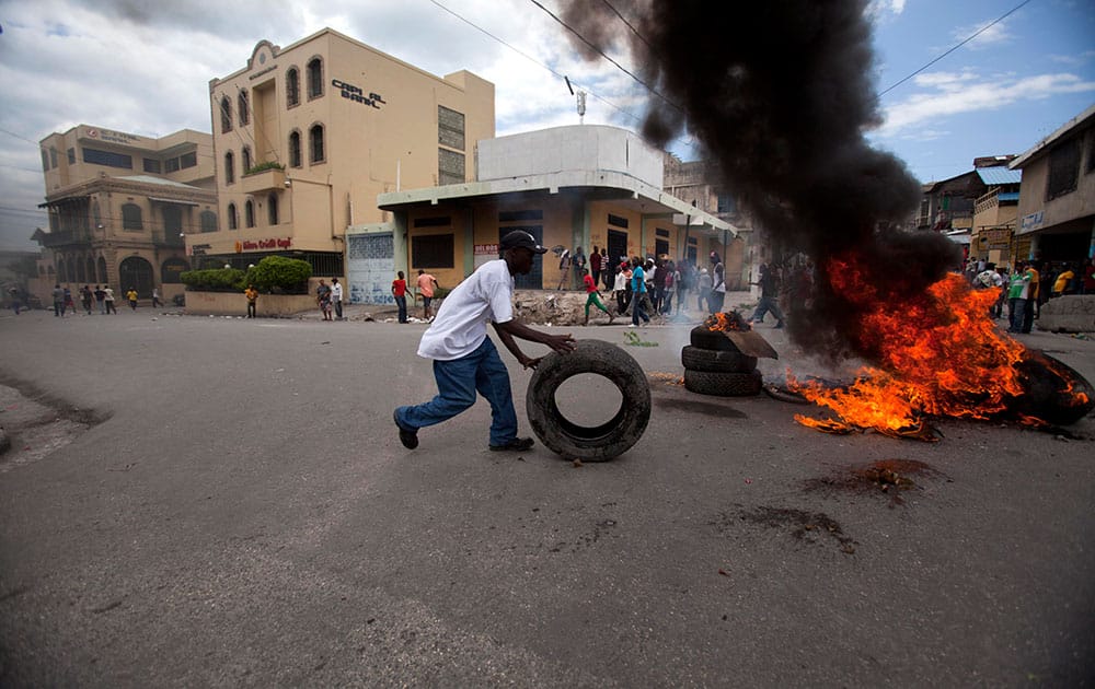 A protester burns tires during an anti-government protest in Port-au-Prince, Haiti.