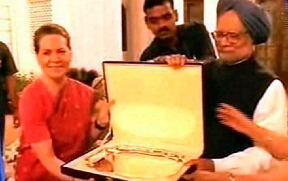 Congress President Sonia Gandhi presents a memento to Prime Minister Manmohan Singh during the farewell dinner hosted by Congress President at her residence 10 Janpath in New Delhi.