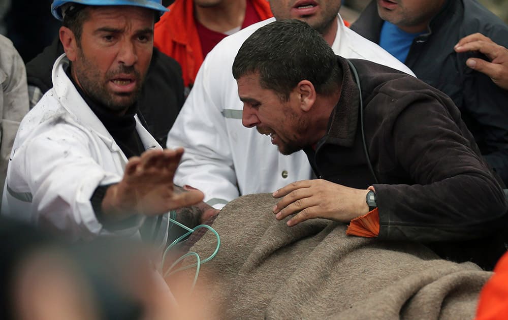 A man reacts as rescue workers carry the body of a miner from the mine in Soma, western Turkey.