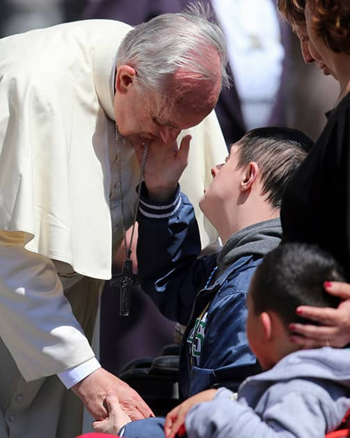 Pope Francis is caressed by faithful in St. Peter`s Square during the weekly general audience, at the Vatican.