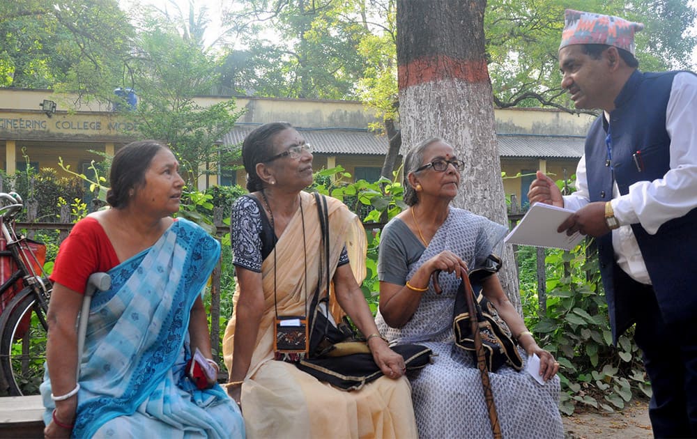 Bhakta Bahadur Karki, a delegate from Nepal is talking to voters at polling station number 245 in B.E college, Shibpur, Howrah. A 14-member delegation from the Election Commission of Nepal witnessed the polls in Howrah district. [Photo: UNDP India]