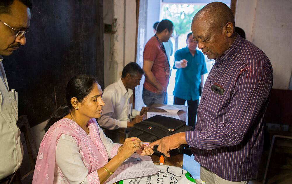 An election officer applies ink on the finger of Dr. Makase Nyaphisi, Commissioner, Independent Electoral Commission, Lesotho, prior to actual polling at a polling center in Municipal Inter College Taj Ganj, Agra, Uttar Pradesh on 24 April 2014. [Photo: UNDP India]