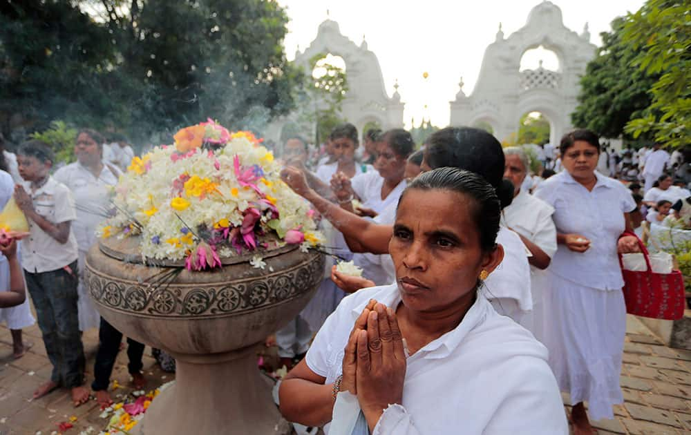 A Sri Lankan Buddhist devotee prays during religious observances on the day of Vesak, or Buddha Purnima, festival at a temple in Colombo.