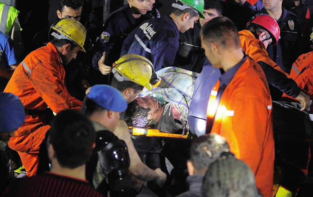 Miners carefully carrying a rescued friend hours after an explosion and fire at a coal mine killed at least 17 miners and left up to 300 workers trapped underground, in Soma, in western Turkey.