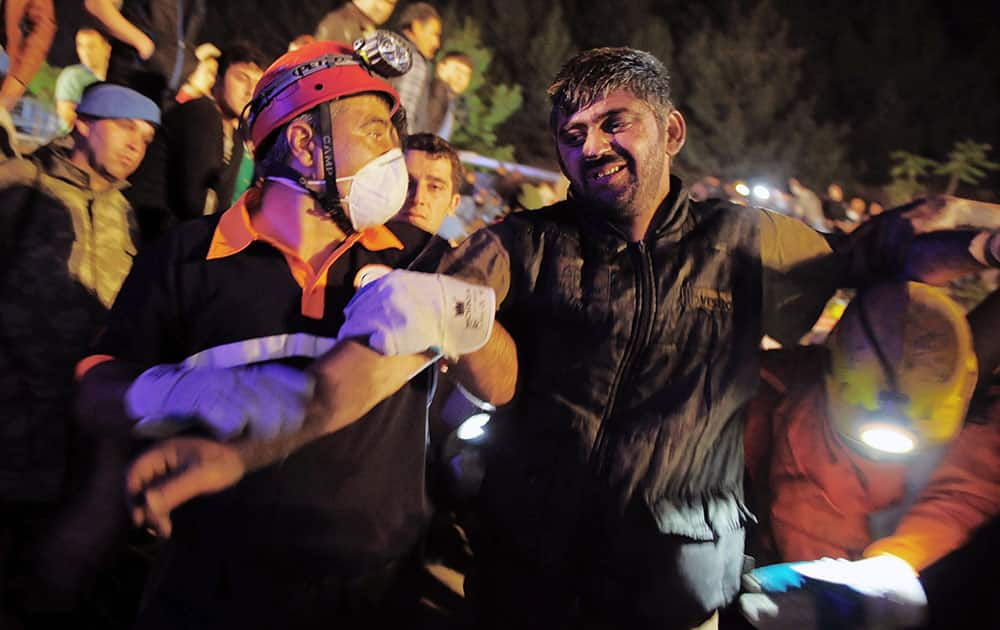 Miners help a rescued friend hours after an explosion and fire at a coal mine killed at least 17 miners and left up to 300 workers trapped underground, in Soma, in western Turkey.