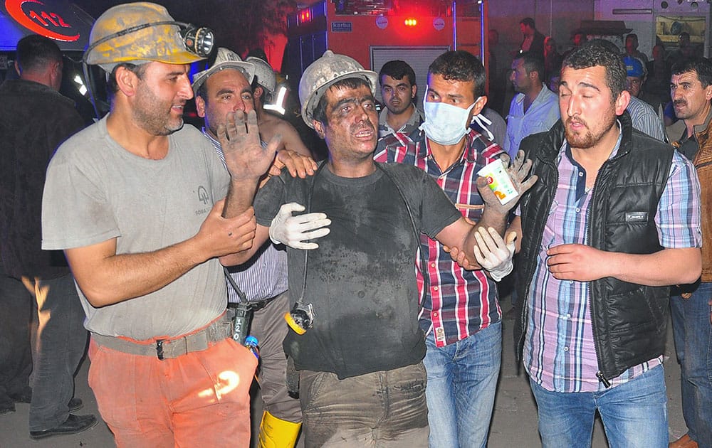 Miners escort a rescued friend after an explosion and fire at a coal mine in Soma, in western Turkey.