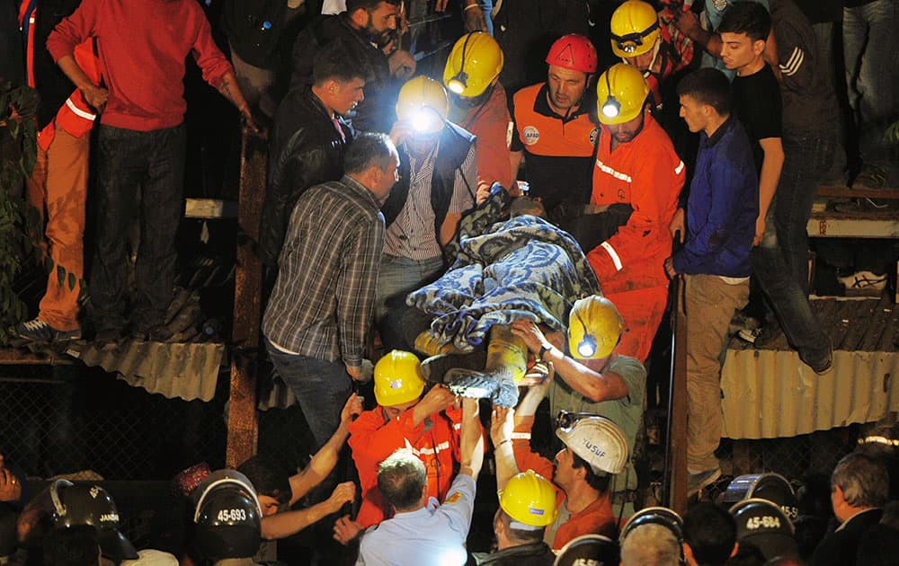 Miners carry a rescued friend hours after an explosion and fire at a coal mine killed at least 17 miners and left up to 300 workers trapped underground, in Soma, in western Turkey.