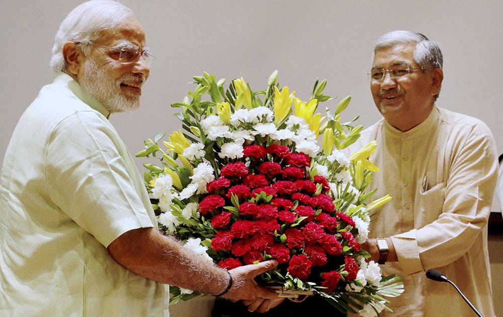 GUJARAT CHIEF MINISTER AND BJP`S PM CANDIDATE NARENDRA MODI IS PRESENTED WITH A BOUQUET BY THE PARTY`S STATE UNIT CHIEF RC FALDU AT A MEETING OF PARTY MLAS IN GANDHINAGAR.