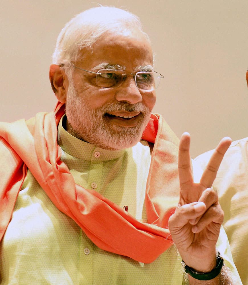 Gujarat Chief Minister and BJP`s PM candidate Narendra Modi flashes victory sign at a meeting with party MLAs in Gandhinagar.