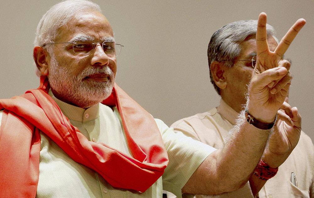 Gujarat Chief Minister and BJP`s PM candidate Narendra Modi flashes victory sign at a meeting with party MLAs in Gandhinagar.