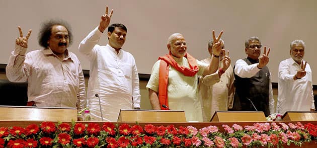 Gujarat Chief Minister and BJP`s PM candidate Narendra Modi flashes victory sign at a meeting with party MLAs in Gandhinagar.
