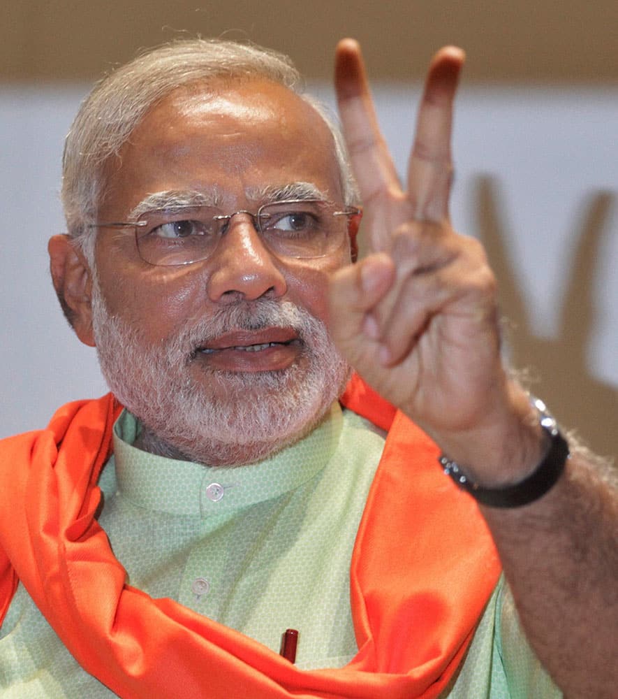 Gujarat Chief Minister and BJP`s PM candidate Narendra Modi flashes victory sign at a meeting with party MLAs in Gandhinagar.