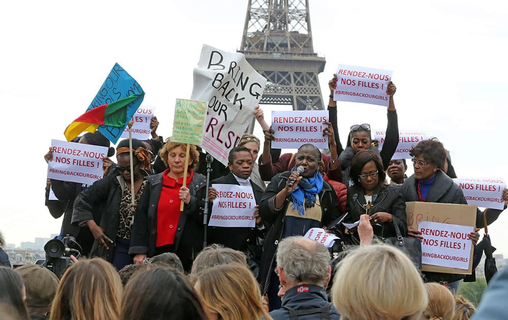 A woman addresses the crowd, as others hold placards saying: Bring back our girls, during a rally at the Trocadero, in front of the Eiffel Tower, to show support for the release of the kidnapped girls in Nigeria in Paris.