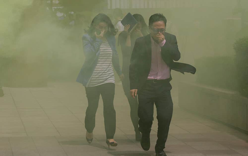 South Koreans cover their faces while escaping from smoke during an emergency fire drill in Seoul.