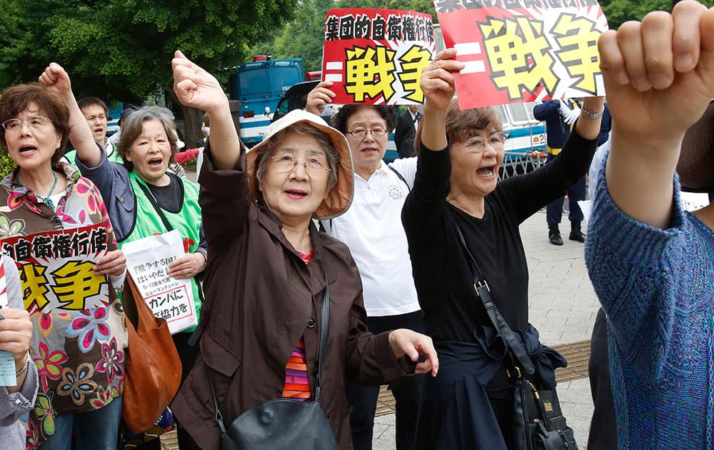 Protesters shout slogans during a march around the Diet building in Tokyo. They gathered around Parliament protesting against the Japanese government`s plan to reform constitution to enable an expanded role for the military. The placards read: `Exercise of the right of collective self-defense equals a war.`