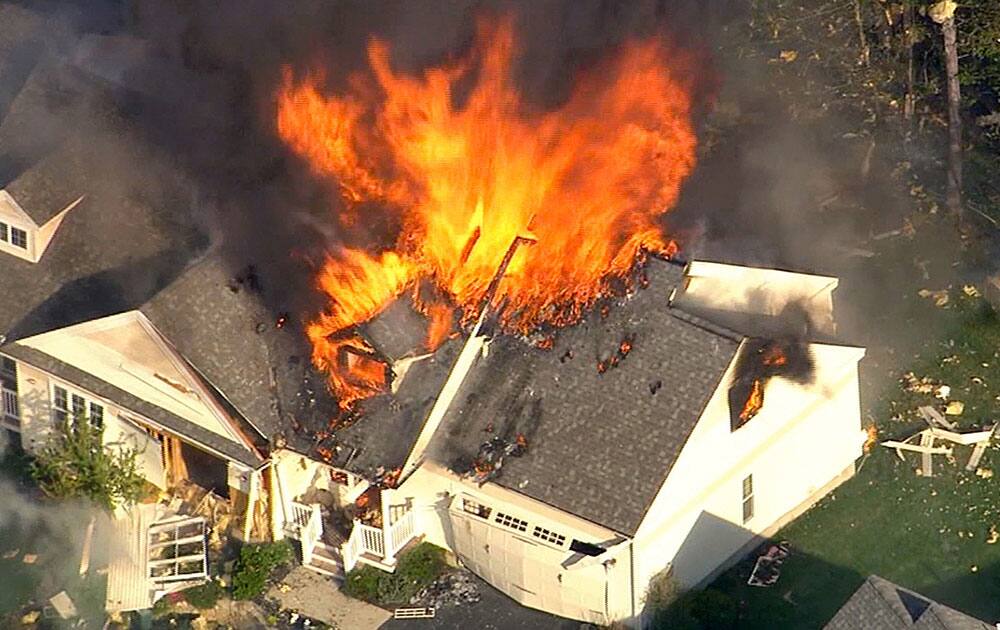 In this frame grab from television helicopter video, a home bursts into flames in Brentwood, N.H. Shots were fired just before the fire, which involved a police officer, according to the New Hampshire State Police.