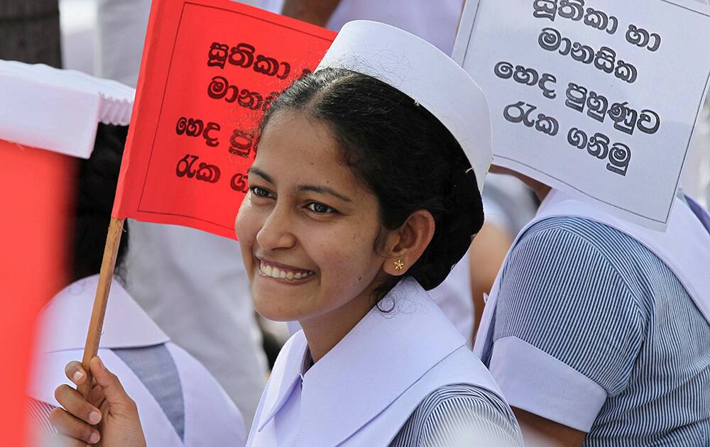 A Sri Lankan nurse smiles at another during a demonstration as they mark International Nurses Day in Colombo, Sri Lanka.