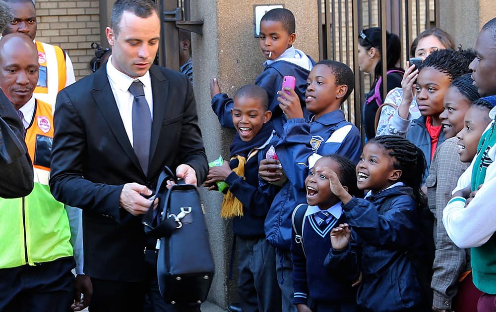 Children react as Oscar Pistorius, left, leaves the high court in Pretoria, South Africa.