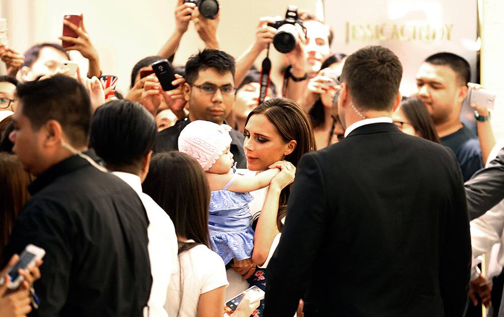 Victoria Beckham carries a baby of a fan upon arrival at the On Pedder store in Singapore. Beckham is here to launch a personal selection of her Spring/Summer 2014, Pre-Autumn/Winter 2014 and ICON collections.