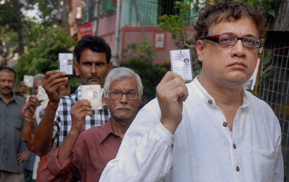 Trinamool Congress Rajya Sabha MP and party leader Derek O`Brian shows his voter card as he stands in a queue to cast his vote for the last phase of Lok Sabha election, in Kolkata.