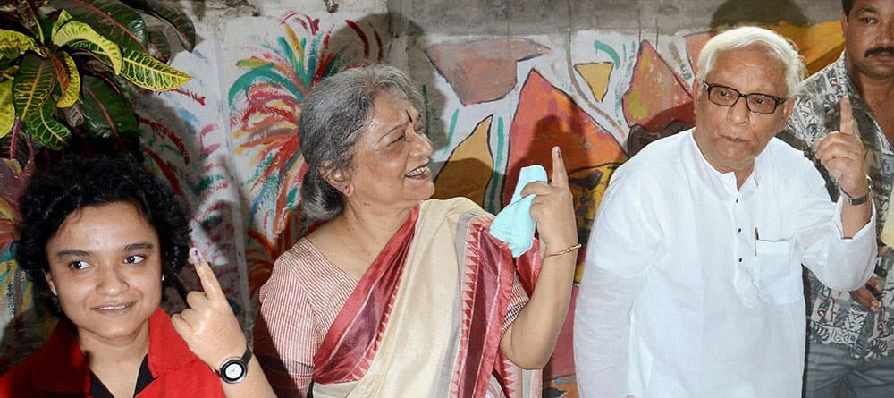CPI-M leader Buddhadeb Bhattacharya shows his inked finger with his wife Mira and daughter Suchetana after casting their votes for Lok Sabha polls in Kolkata.